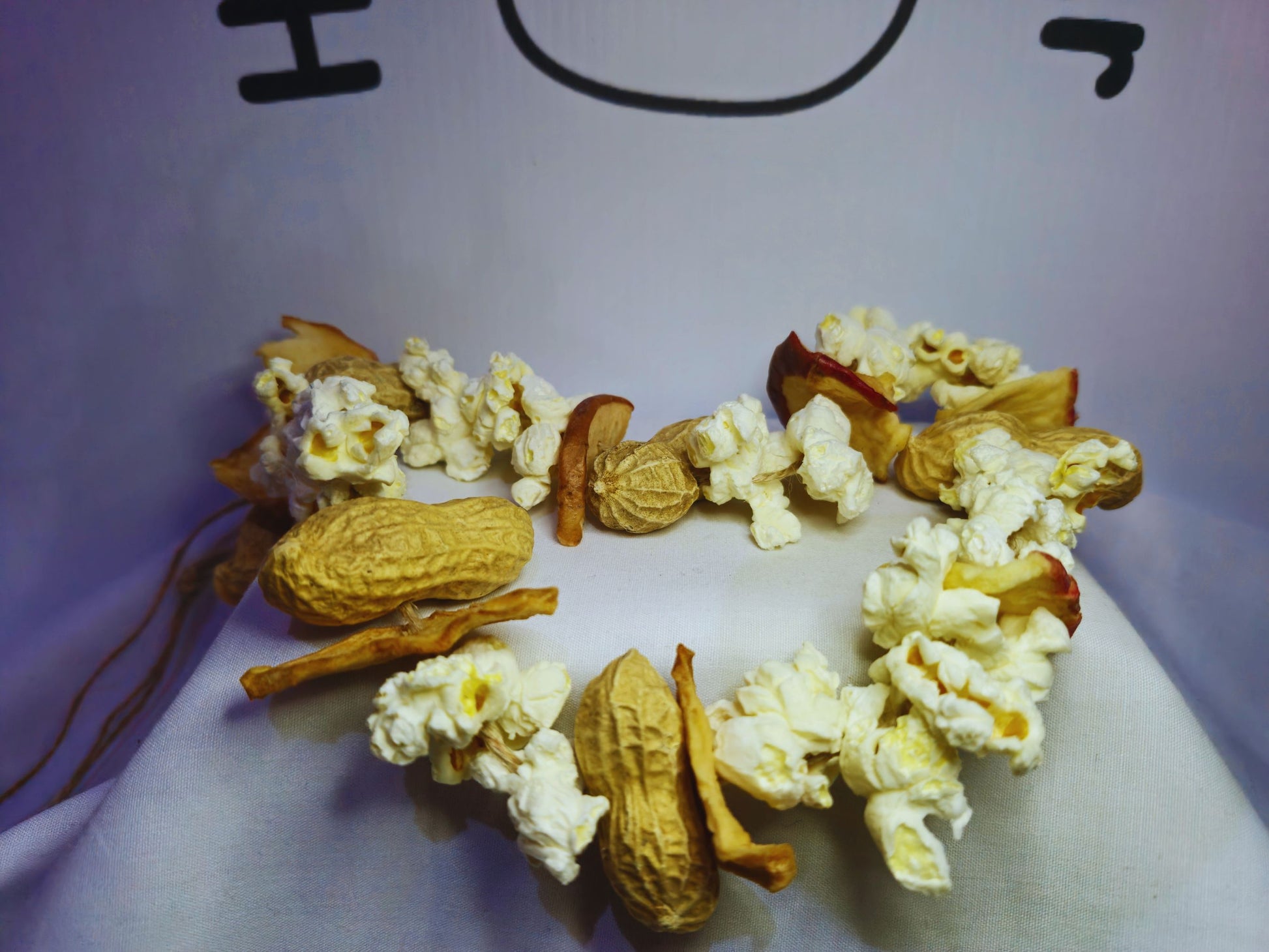 A close up of the hamster chewy garland featuring popcorn, apple and monkey nuts.