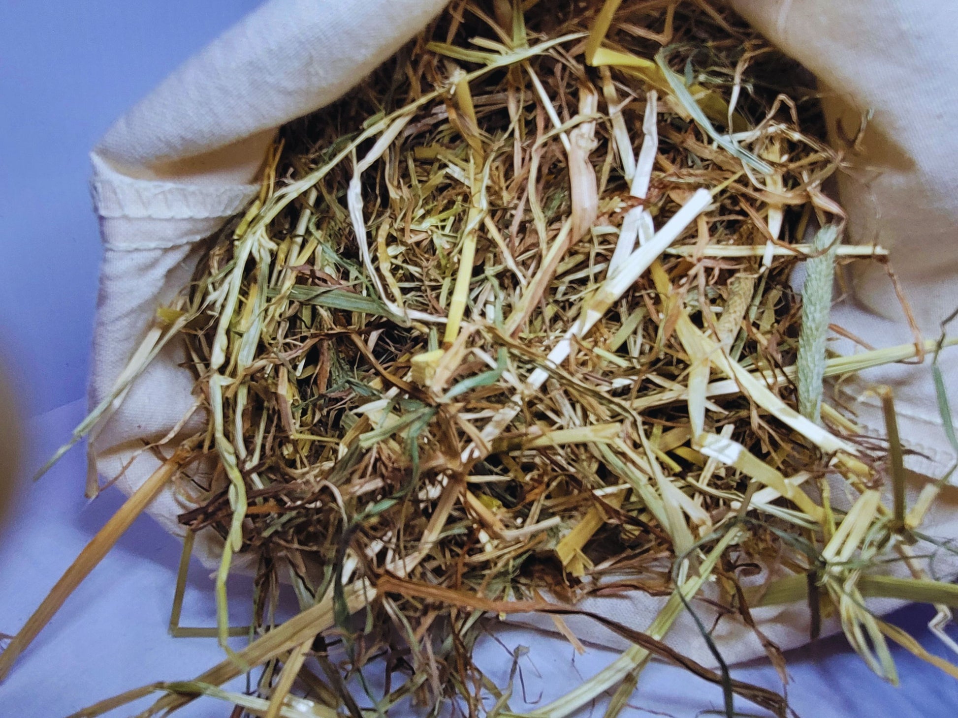 A close up picture of hamster safe hay in a cotton bag