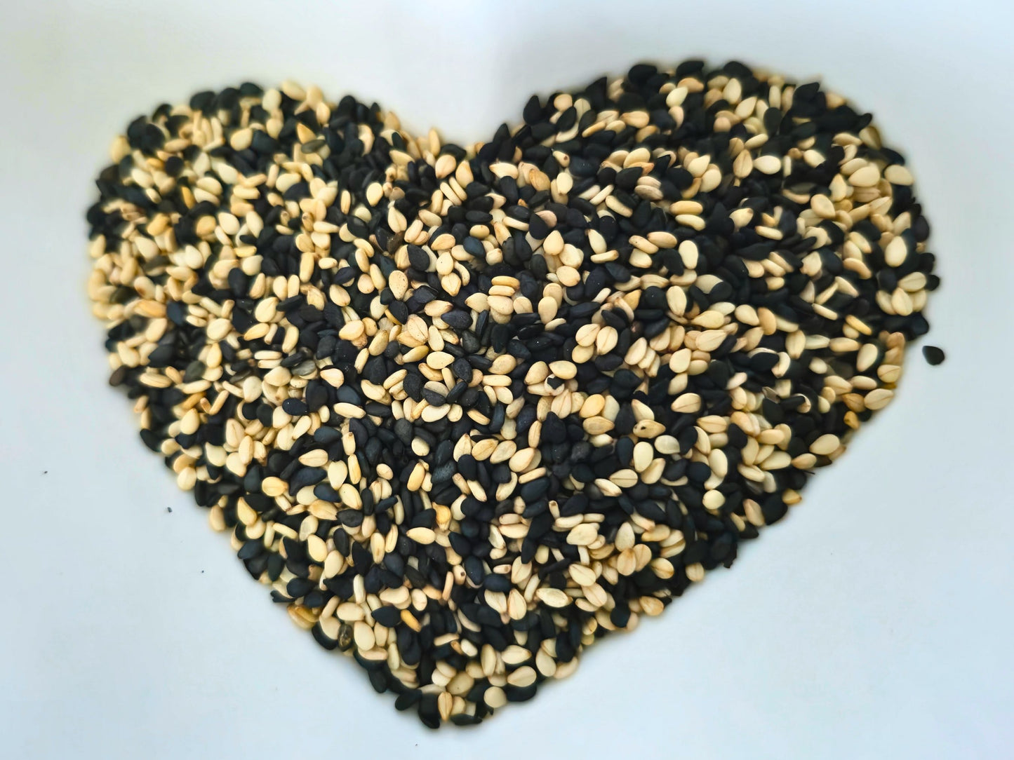 Close-up of black and white sesame seeds arranged in a heart