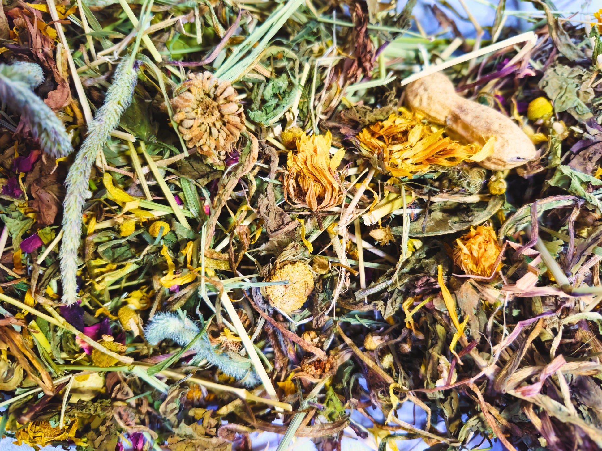 A close up of the hamster safe forest forage containing hay, leaves, dried flowers and snacks.