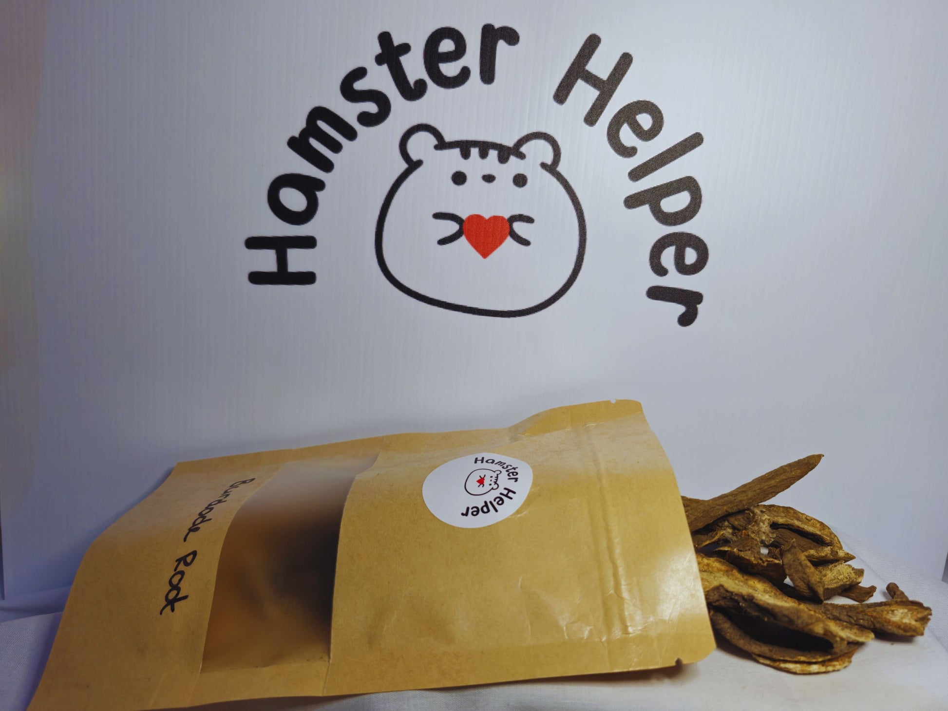 A close up of hamster safe burdock roots spilling out of a bag that has the hamster Helper logo on it.