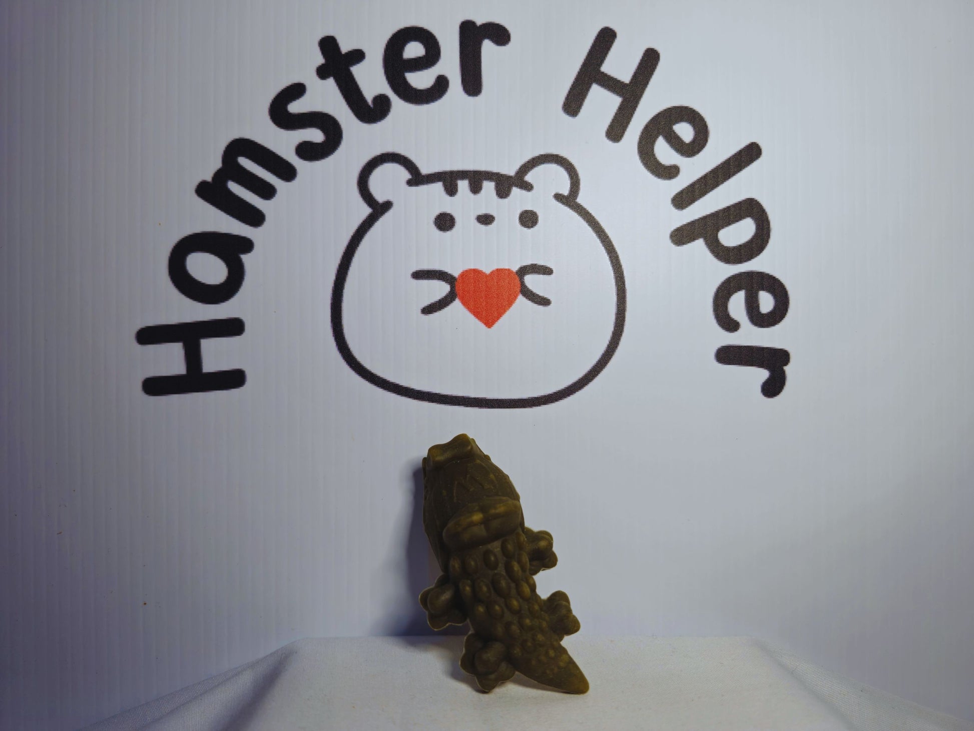 An alligator whimzee for hamsters underneath the Hamster Helper logo