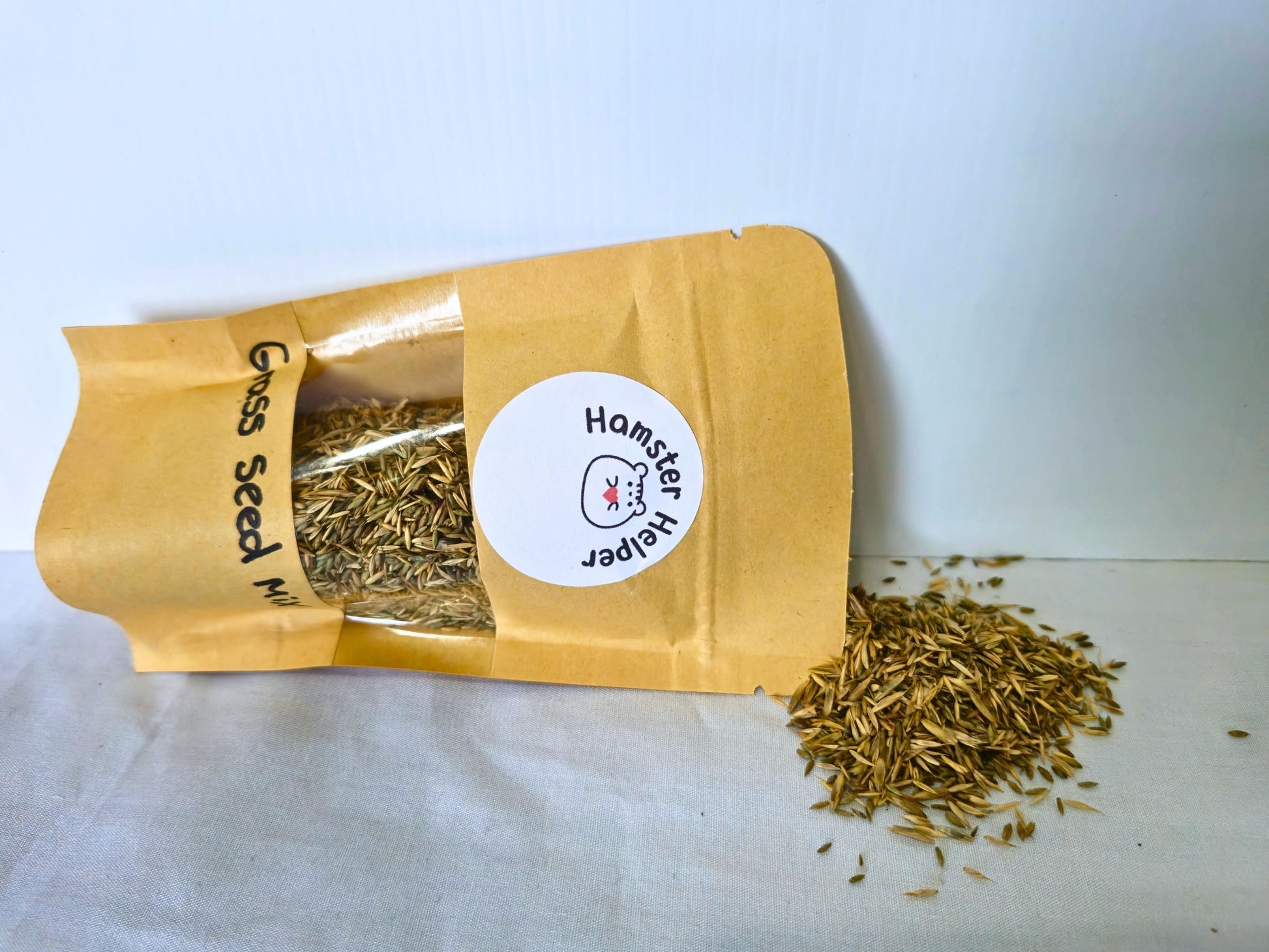 Grass Seed Mix pouch with the fine seeds scattered beside it