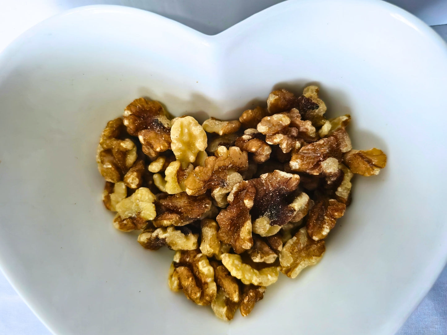 Plain walnut pieces presented in a heart-shaped bowl