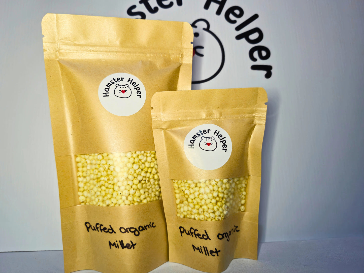 A large and small pouch of hamster safe organic puffed millet with Hamster Helper stickers on the pouches.