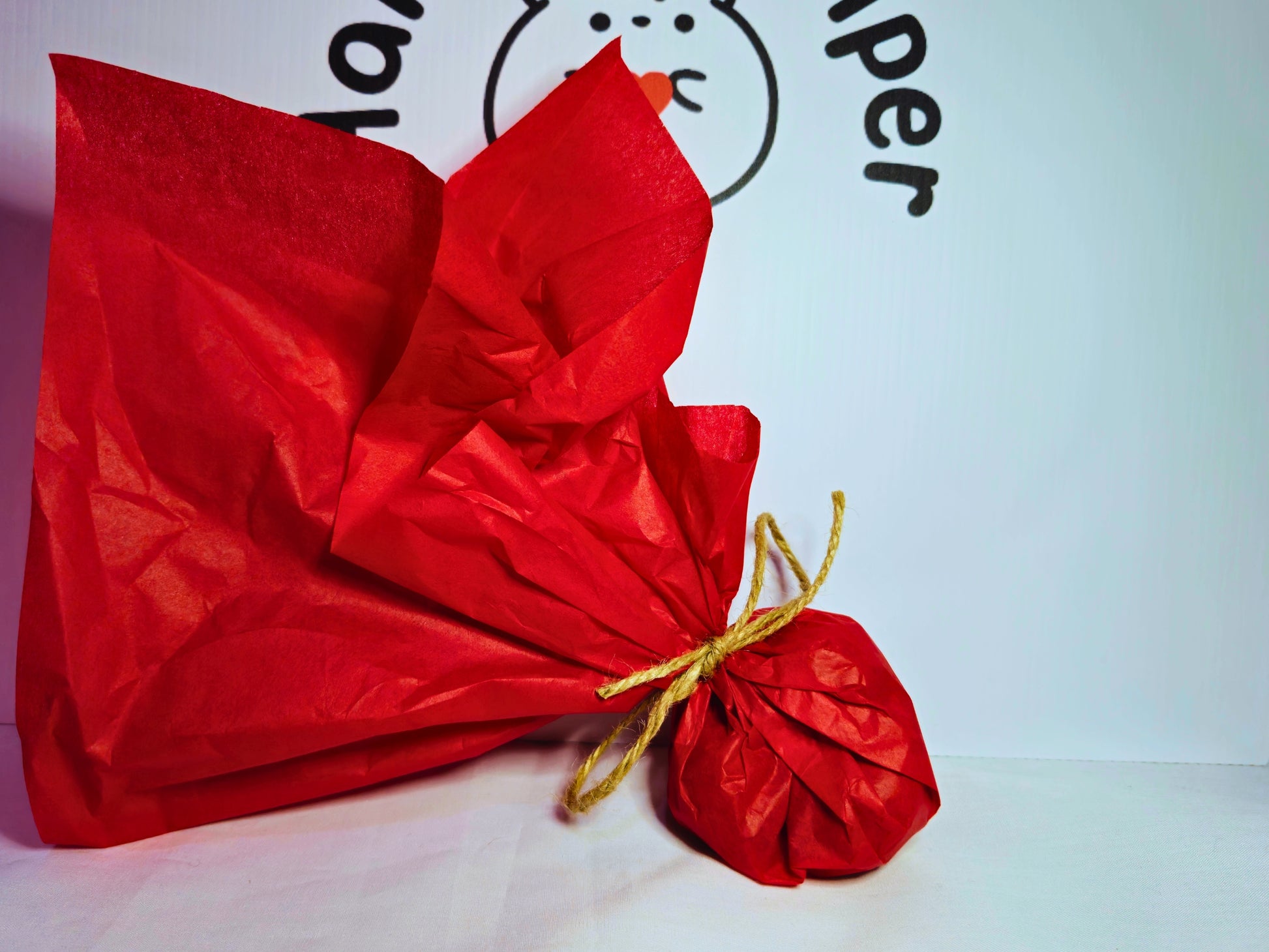 Three walnuts wrapped in red tissue paper and tied with jute twine to demonstrate the whole walnuts for hamsters packaging.