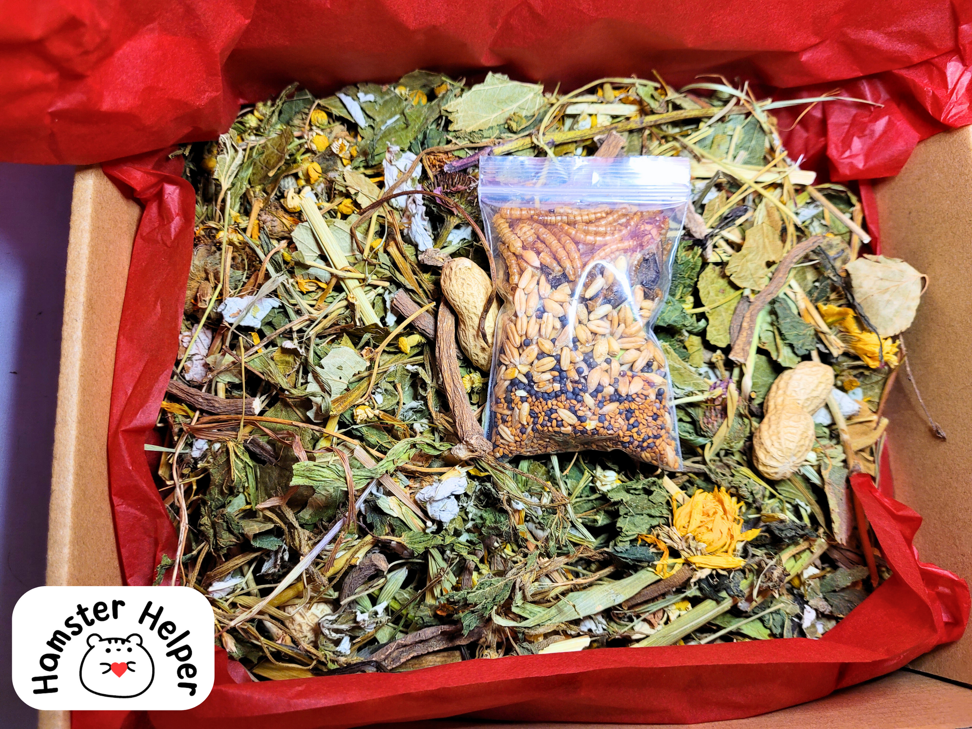 A close up of the hamster safe forage mix showing the crunchy topper resting on top of the forage mix inside a cardboard box that is lined with red tissue paper