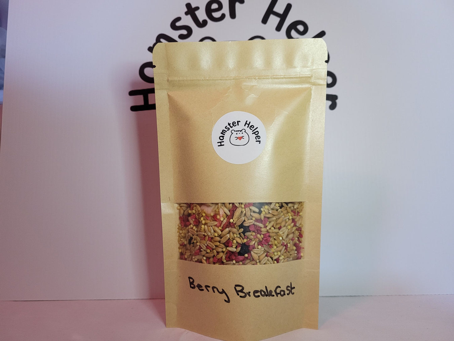 The berry breakfast hamster treat mix in a food pouch that has the hamster helper logo on it.