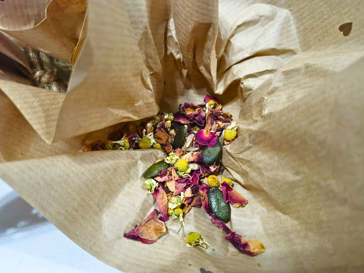Colorful dried flowers, seeds and grains shown inside a valenties scrunchy muncher. 