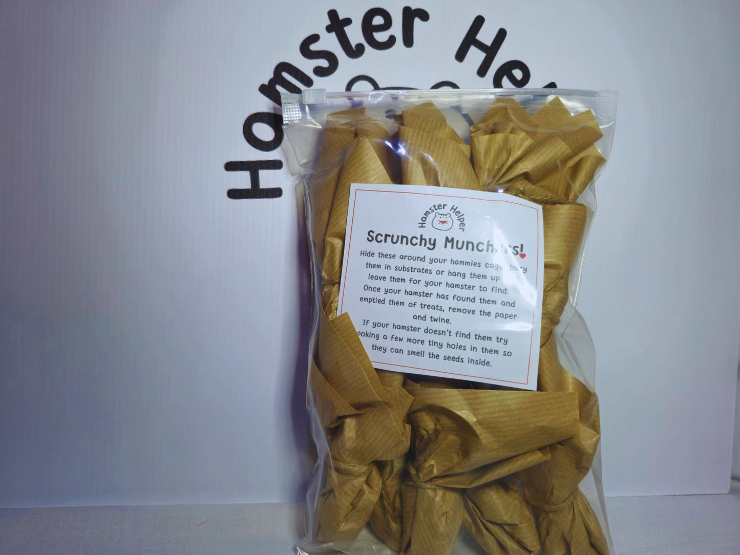 A pack of ten scrunchy muncher hamster chew toys in a bag demonstrating packaging. The bag has a label with text on it explaining how to use the scrunchy munchers.