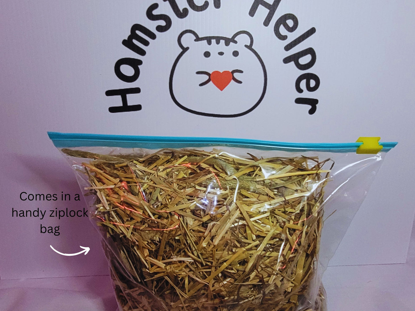 A ziplock bag containing hamster safe hay in front of the Hamster Helper logo