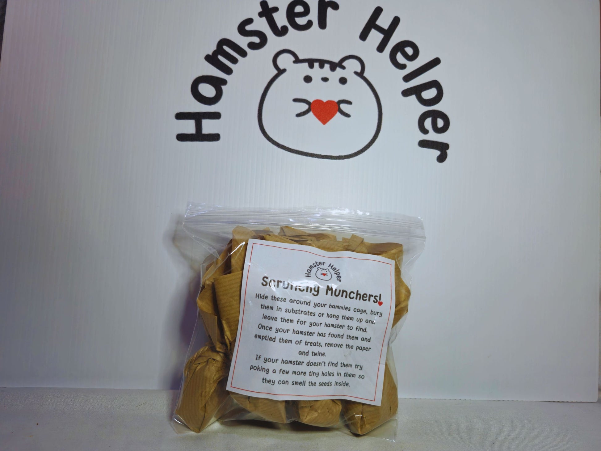 Five scrunchy muncher hamster chew toys in a bag demonstrating packaging. The bag has a label with text on it explaining how to use the scrunchy munchers.