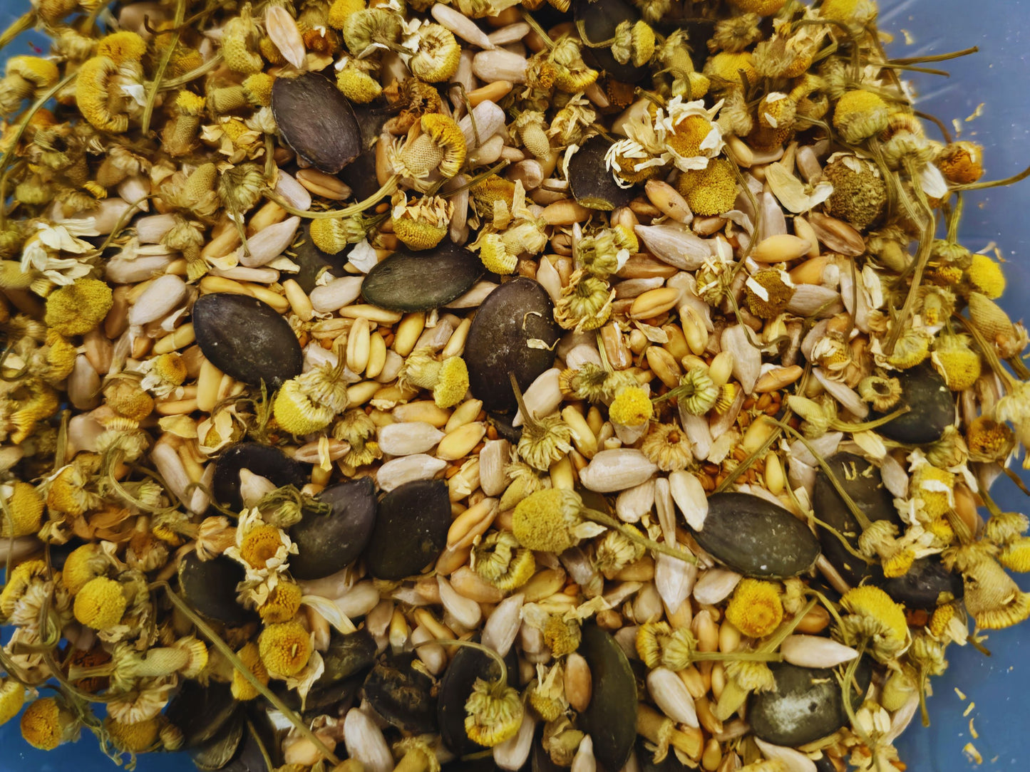 A close up of the chamomile charm crunch treat mix containing dried chamomile, grains and seeds.