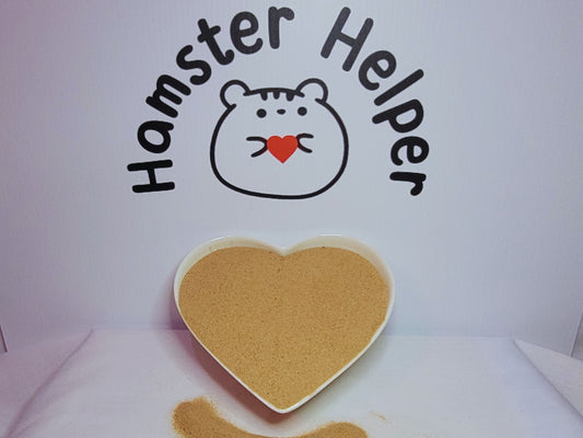 A heart shaped dish filled with hamster safe sand displayed in front of the Hamster Helper logo