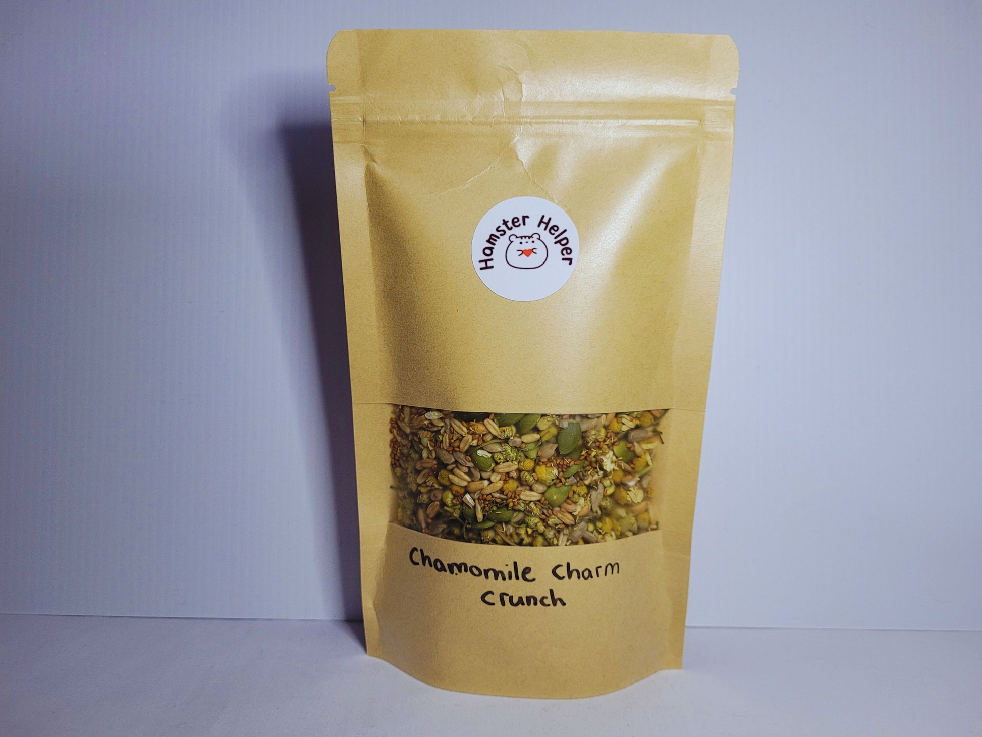 A pouch of hamster safe chamomile charm crunch treat mix with the hamster Helper logo on it.