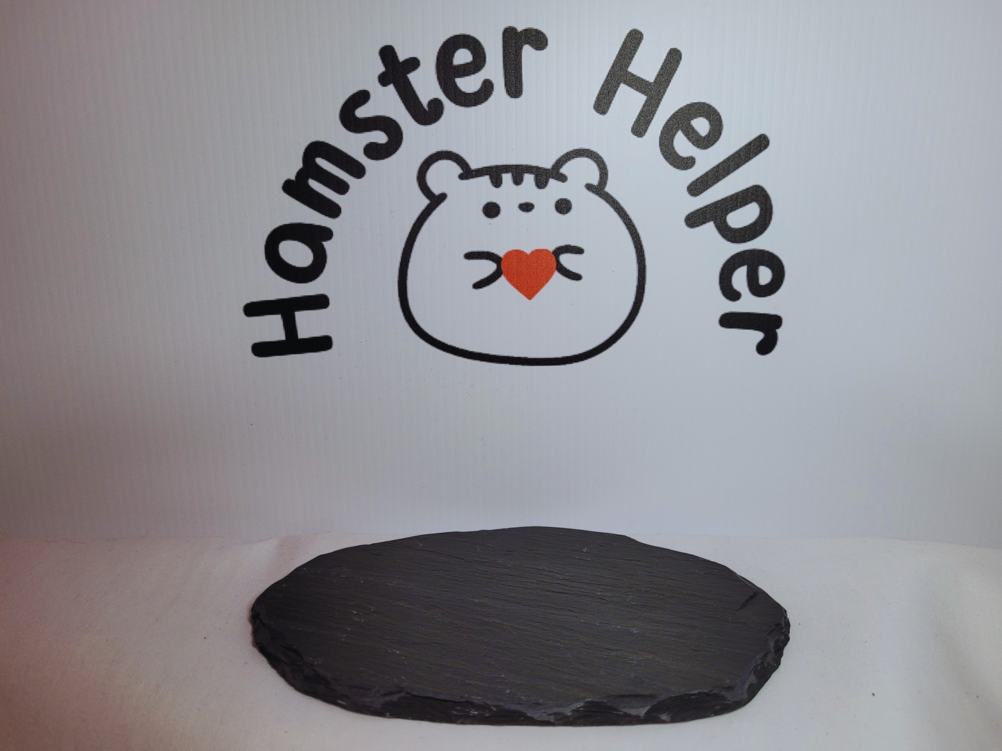 An XL hamster nail maintenance slate in front of the Hamster Helper logo