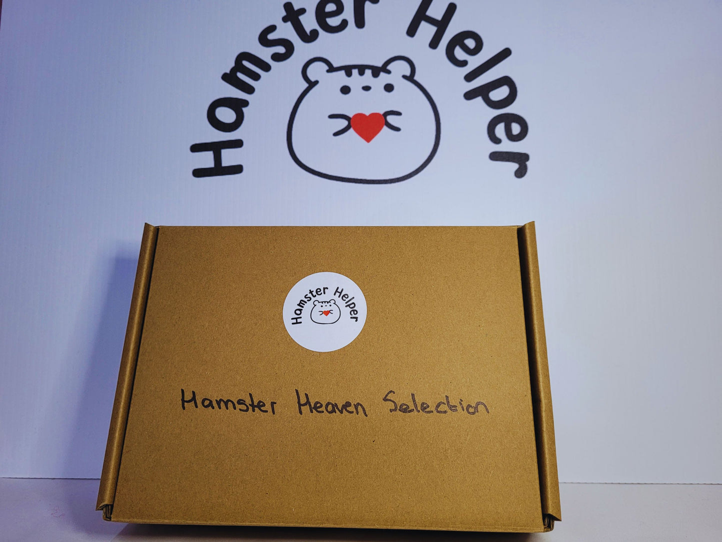 The hamster heaven treat selection in a package in front of the Hamster Helper logo.